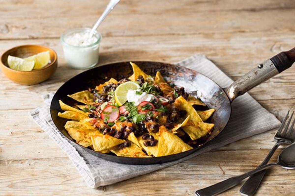 Skillet Chilaquiles: Adobo Black Beans, Pickled Radish, and Sour Cream